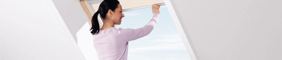 Lady operating Velux window in loft conversion